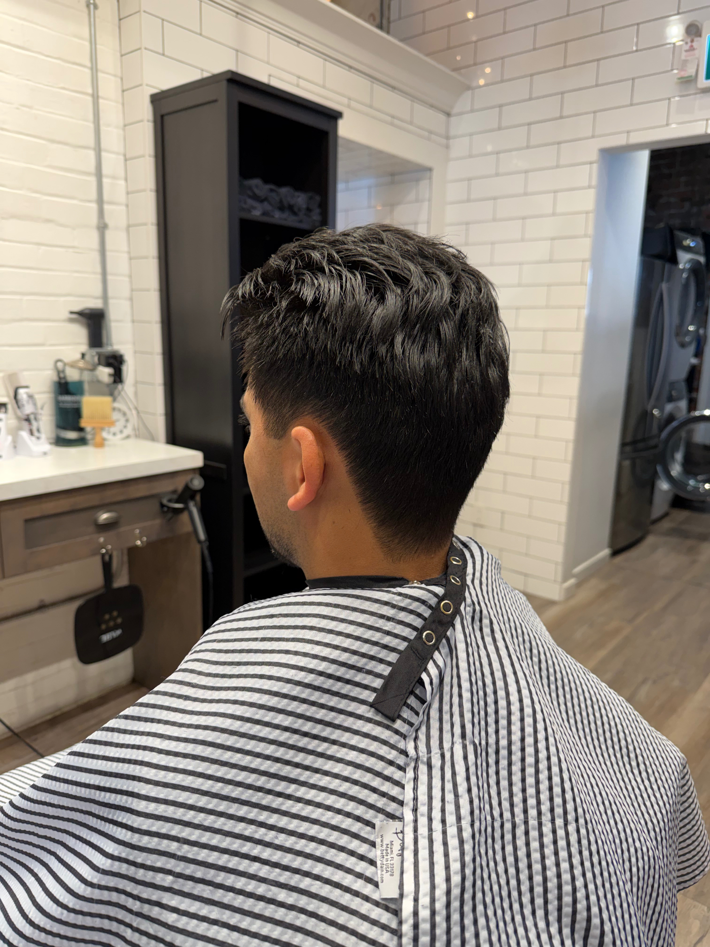 Layered tapered cut, dark hair from the back